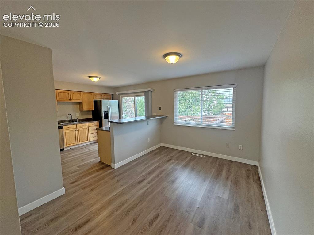 Image 12 of 42: Kitchen featuring wood-finish cabinetry, a peninsula with a breakfast bar,