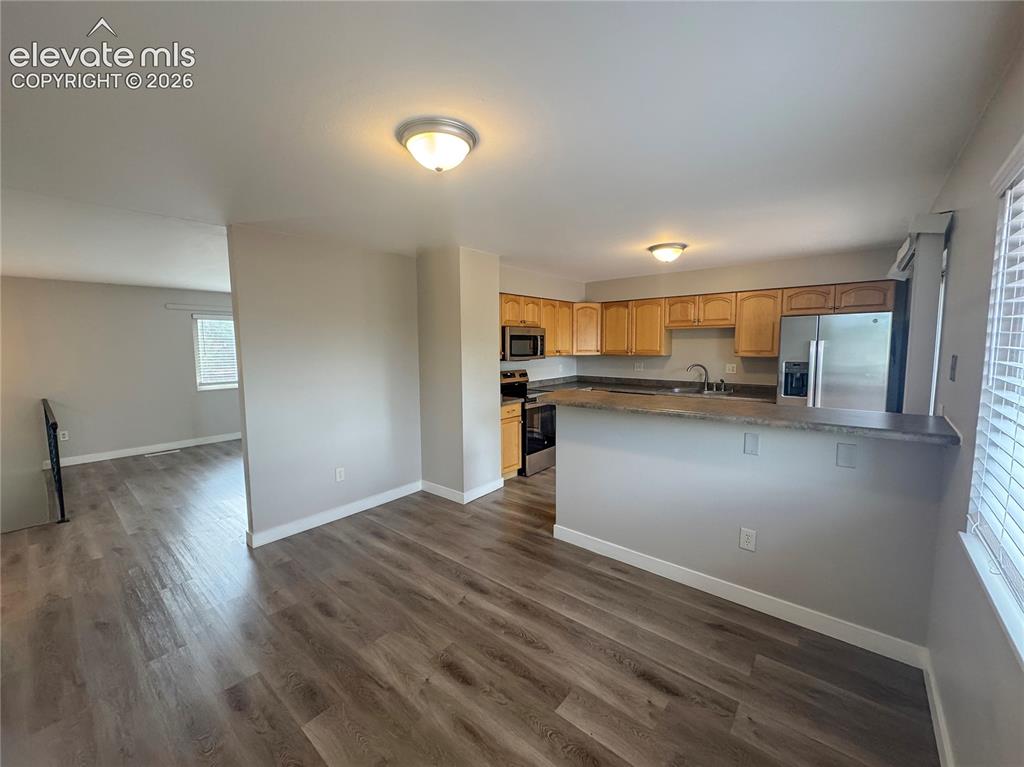 Image 13 of 42: Kitchen featuring light-finish wood cabinetry, stainless steel appliances,