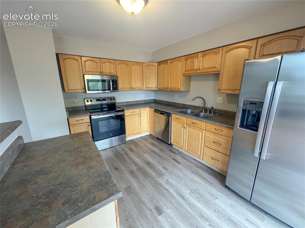 Image 14 of 42: Kitchen featuring wood-finish cabinetry, stainless steel appliances, dual-b