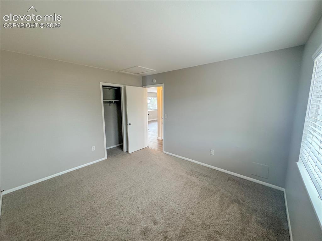 Image 18 of 42: Neutral-toned interior room featuring wall-to-wall carpeting, an integrated