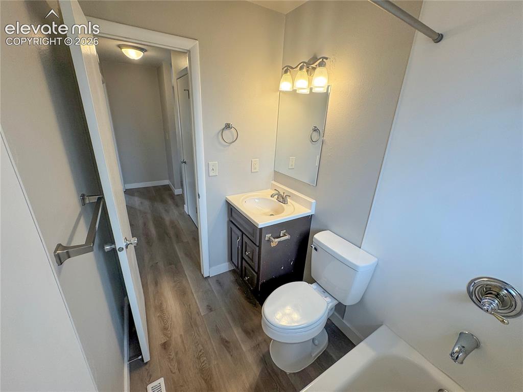 Image 20 of 42: Bathroom featuring a vanity with a white integrated sink, three-light vanit