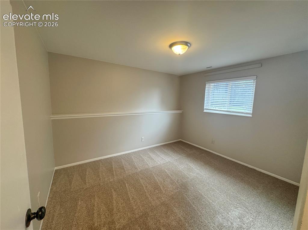 Image 22 of 42: Neutral-toned interior room featuring wall-to-wall carpeting, horizontal wi