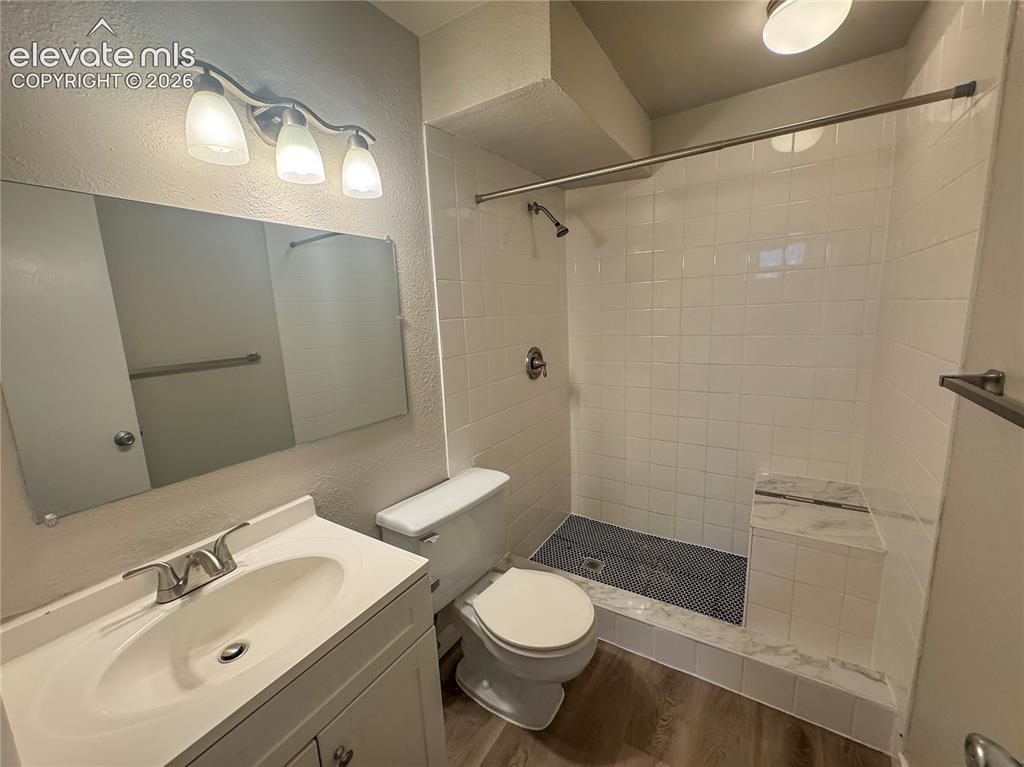 Image 25 of 42: Bathroom featuring wood-finish flooring, a vanity with an integrated sink,
