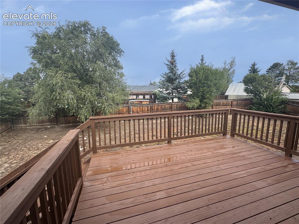Image 33 of 42: Elevated wood deck featuring vertical baluster railings, enclosing a spacio