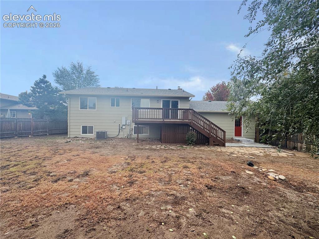 Image 37 of 42: Rear exterior featuring light-toned horizontal siding, a raised wood deck w