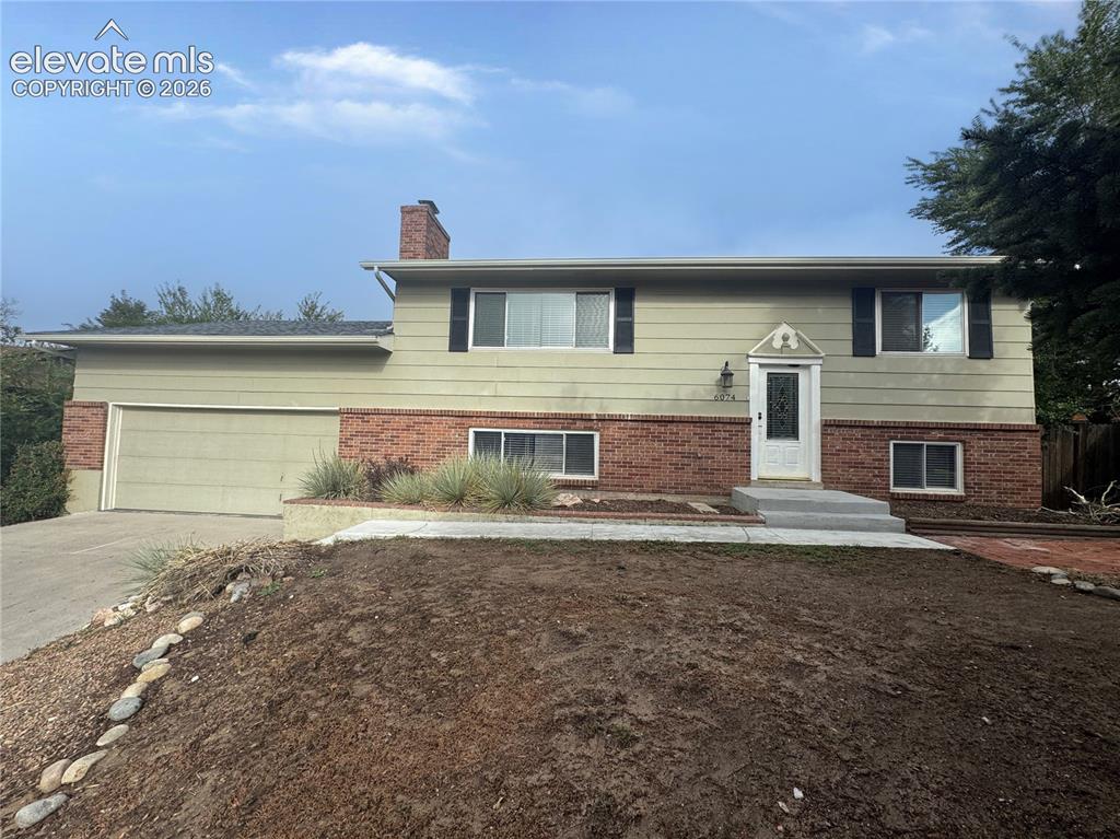 Image 40 of 42: Split-level exterior featuring a combination of brick and horizontal siding