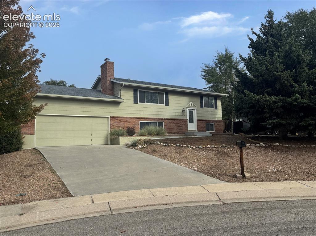 Image 41 of 42: Split-level exterior featuring a brick and horizontal siding facade, attach