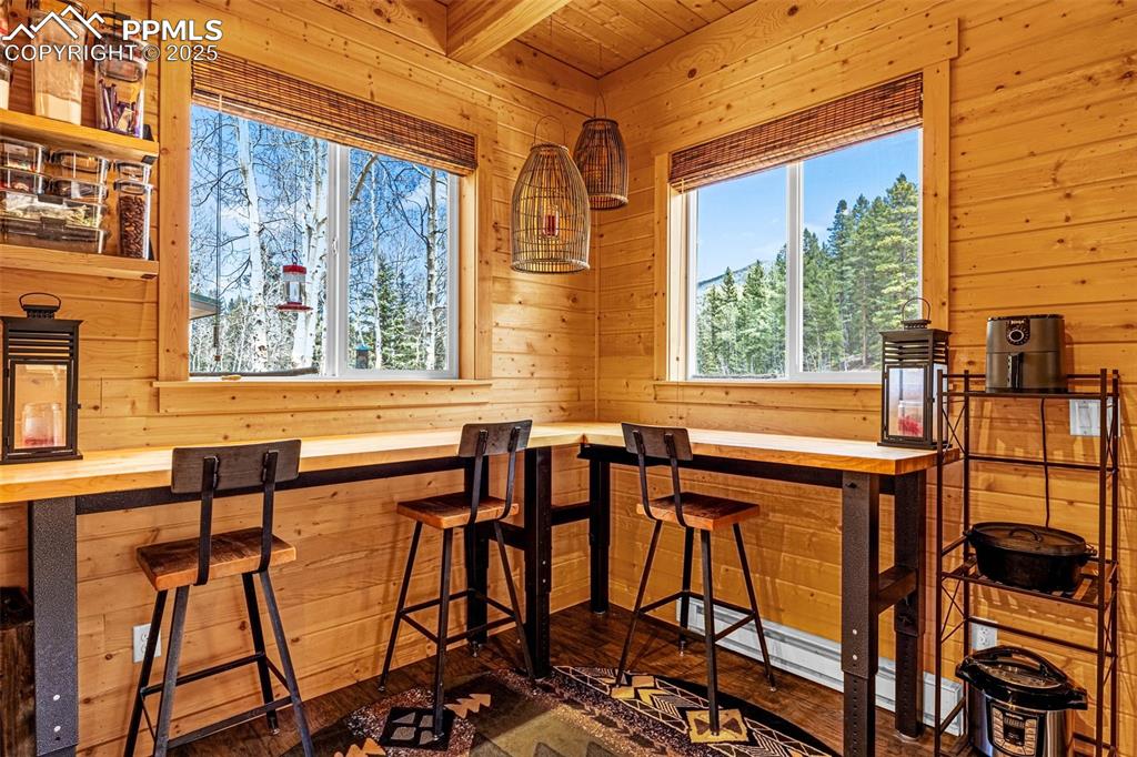 Image 11 of 45: Bar area featuring wood walls, hardwood / wood-style floors, and wooden cei