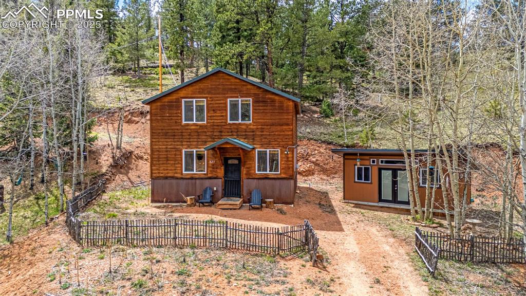 Image 2 of 45: Rustic home with an outbuilding and french doors