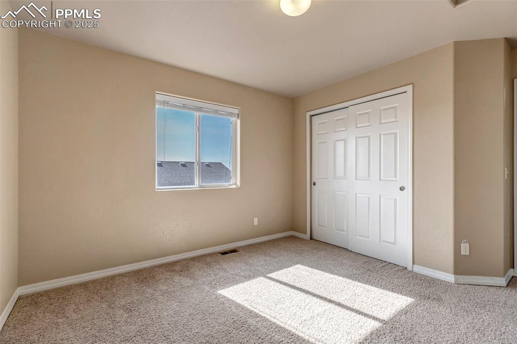 Image 16 of 29: Unfurnished bedroom with a closet and carpet flooring