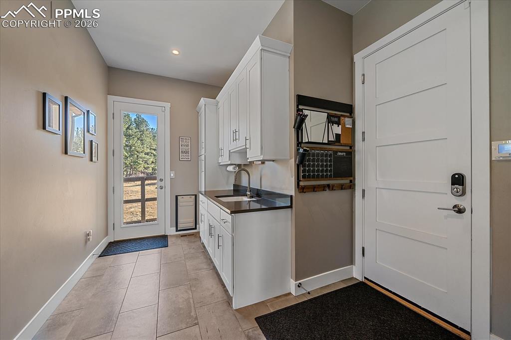 Image 21 of 50: Mudroom entry - note the man door and built in dog door that lead to the fe