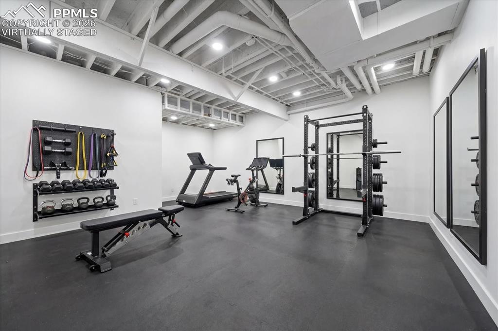 Image 38 of 50: Virtually staged gym room in current unfinished space