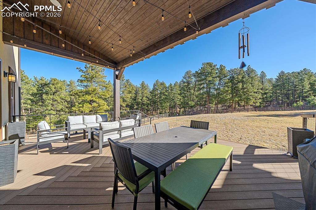 Image 40 of 50: Spacious covered deck overlooking the expansive yard