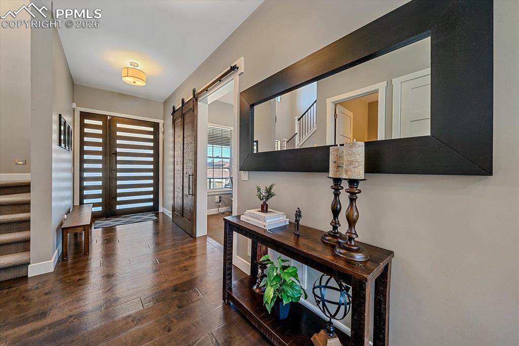 Image 6 of 50: Entry featuring a custom front door and barn door leading into the dedicate