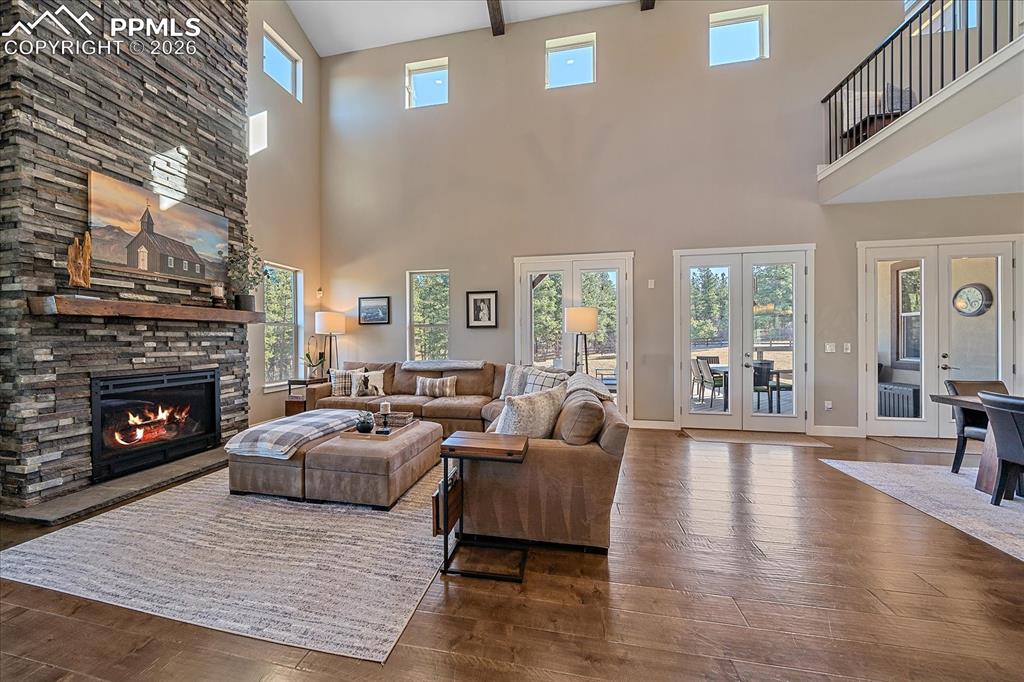 Image 9 of 50: The two story great room is anchored by a floor to ceiling fireplace and ha