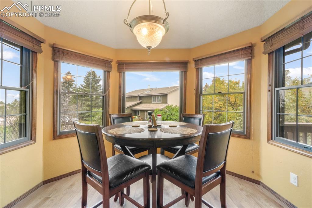 Image 12 of 50: Oversized eat in kitchen with hard wood floors and abundant light