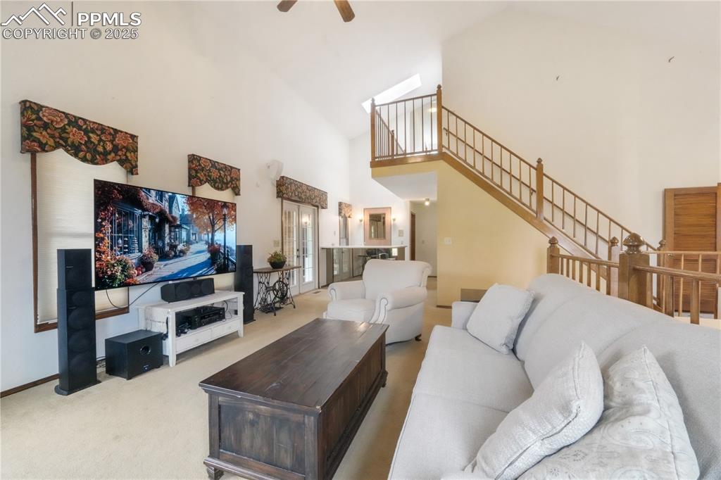 Image 16 of 50: Main level living room, wood burning fireplace, vaulted ceilings, abundant