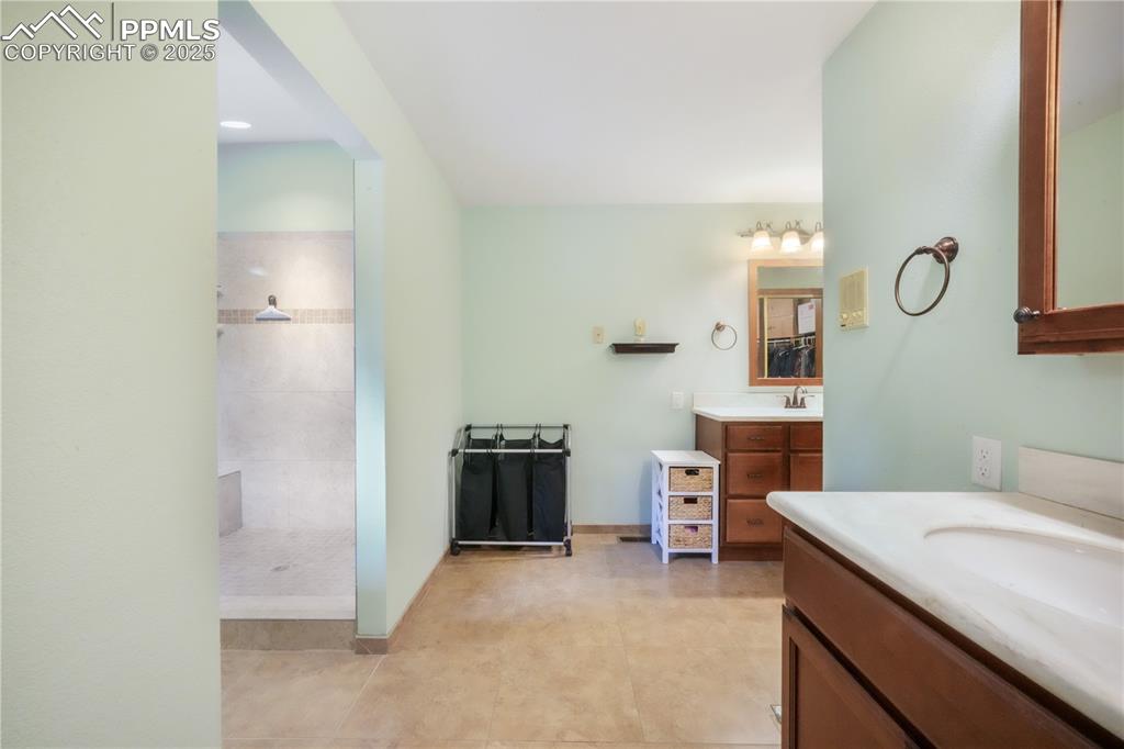 Image 23 of 50: Primary bathroom, dual vanities, expansive walk in shower and access out to