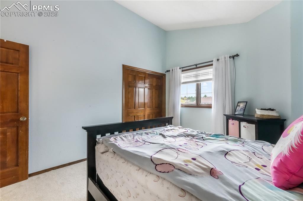 Image 29 of 50: Upper level 2nd bedroom with vaulted ceilings