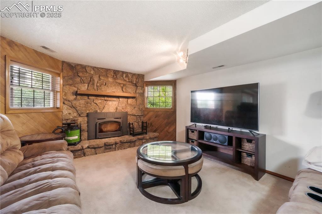 Image 37 of 50: Walk out basement family room with wood burning fireplace and extra room fo