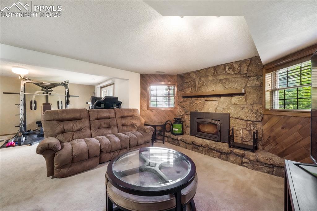 Image 38 of 50: Walk out basement family room with wood burning fireplace and extra room fo