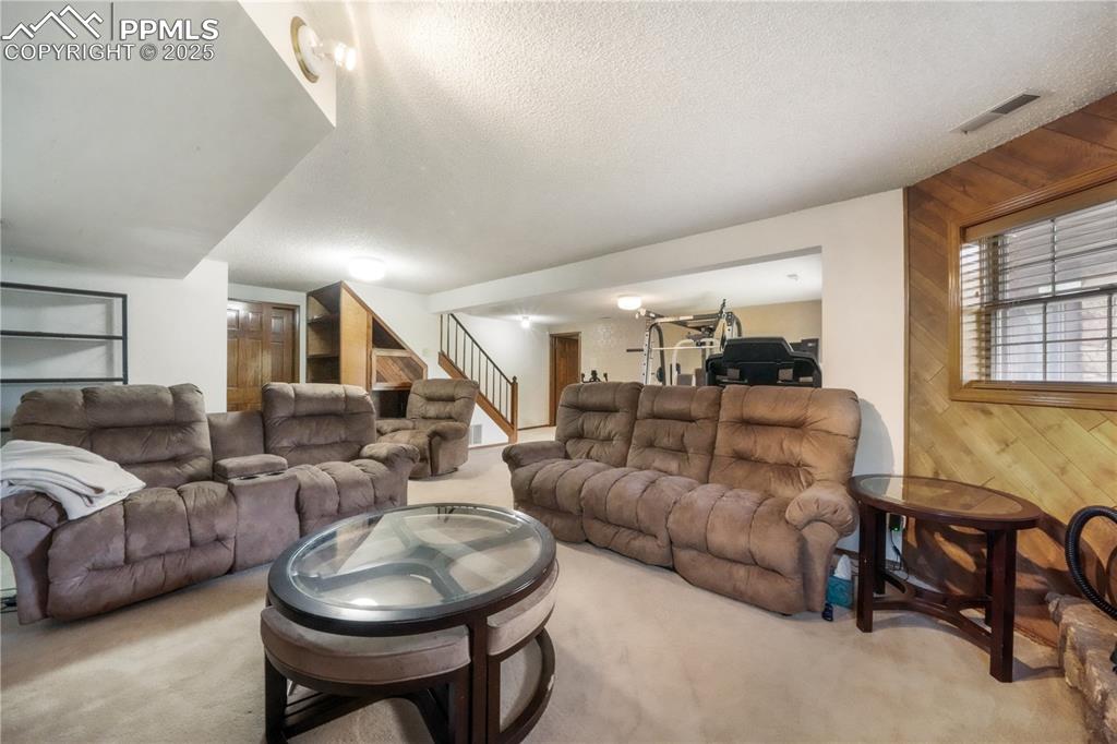 Image 39 of 50: Walk out basement family room with wood burning fireplace and extra room fo