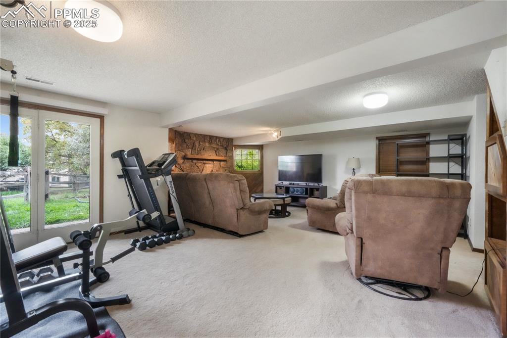 Image 40 of 50: Walk out basement family room with wood burning fireplace and extra room fo