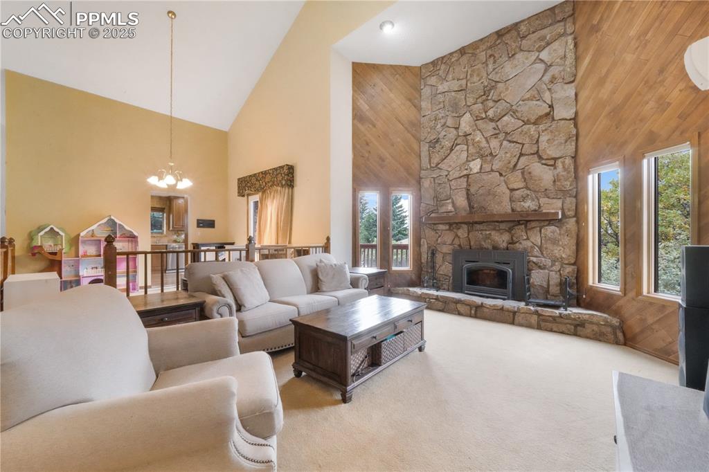Image 5 of 50: Main level living room, wood burning fireplace, vaulted ceilings, abundant