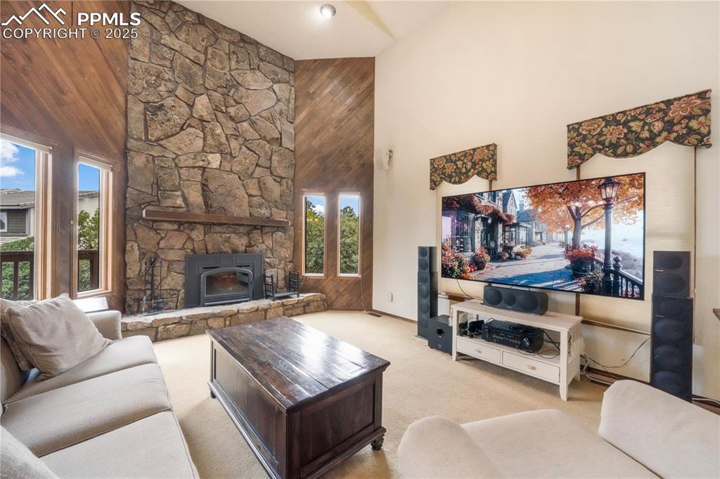 Image 6 of 50: Main level living room, wood burning fireplace, vaulted ceilings, abundant