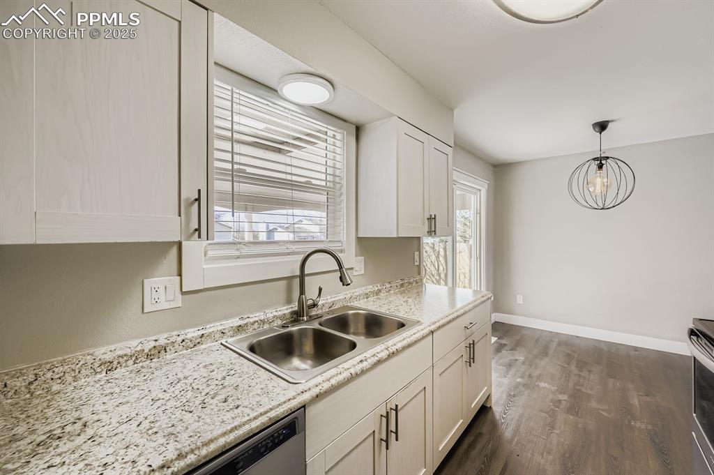 Image 10 of 28: Modern, clean, sparkling kitchen with granite and view to dining area.