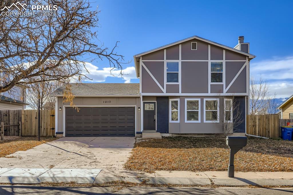 Image 2 of 28: View of front of property featuring concrete driveway, a chimney, and an at