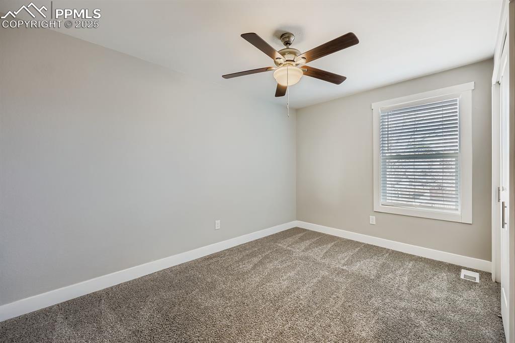 Image 20 of 28: Unfurnished room with carpet and a ceiling fan