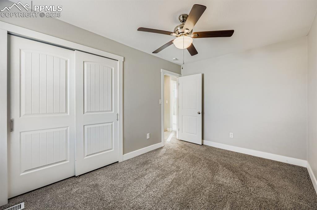 Image 23 of 28: Unfurnished bedroom with carpet floors, a closet, and ceiling fan