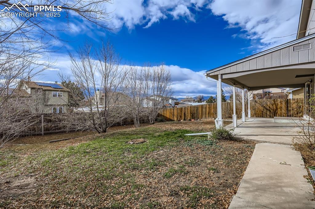 Image 28 of 28: Rear yard, fully fenced, and covered patio... yes, Rocky Mountain Views!