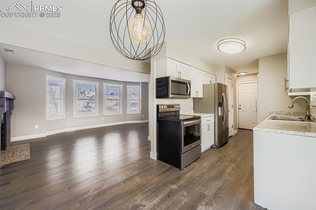 Image 7 of 28: View to kitchen and main living area  with wonderful windows, and open feel