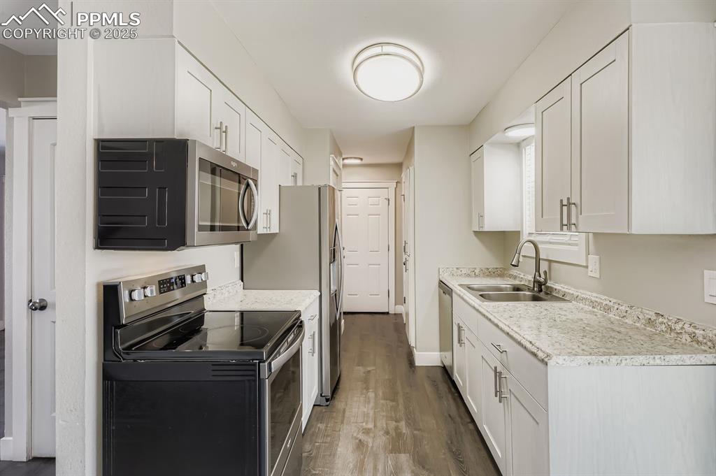 Image 9 of 28: Nice galley kirchen with newer updates... stainless and bright with window 