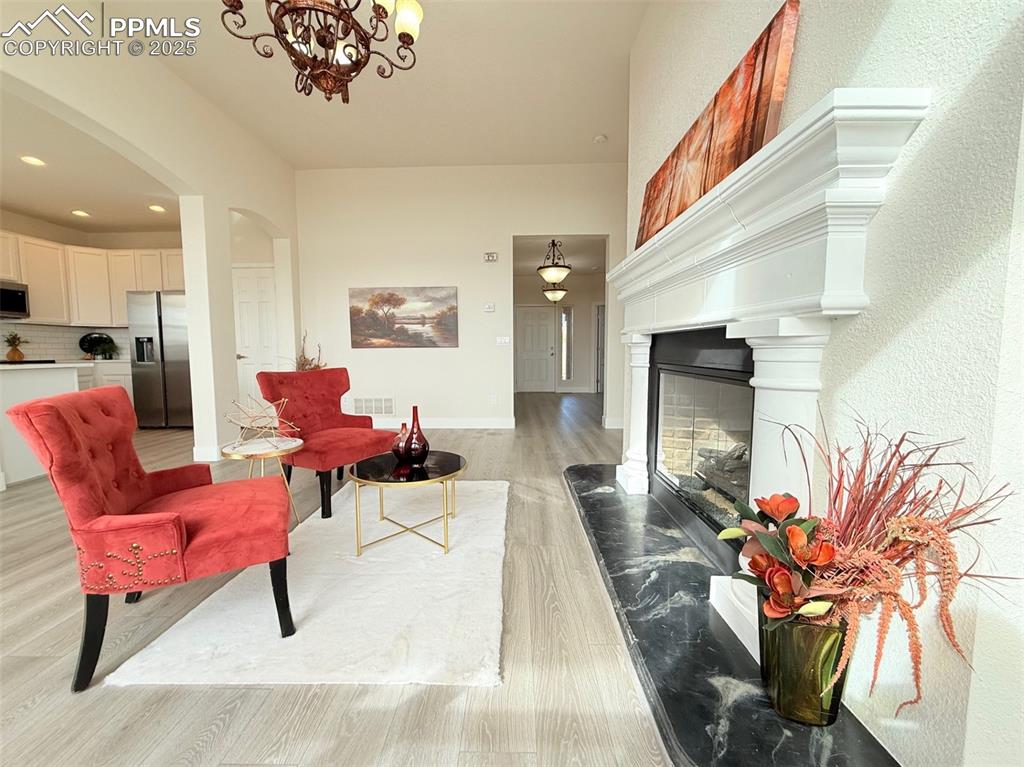 Image 10 of 49: Living area featuring light wood-style flooring, arched walkways, recessed 