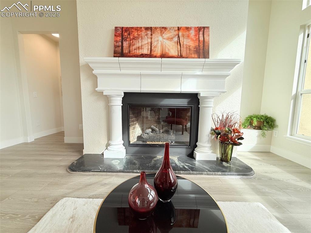 Image 11 of 49: Detailed view of wood finished floors, a fireplace, and a textured wall