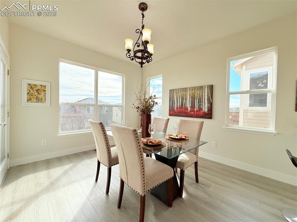 Image 17 of 49: Dining space featuring light wood finished floors and a chandelier