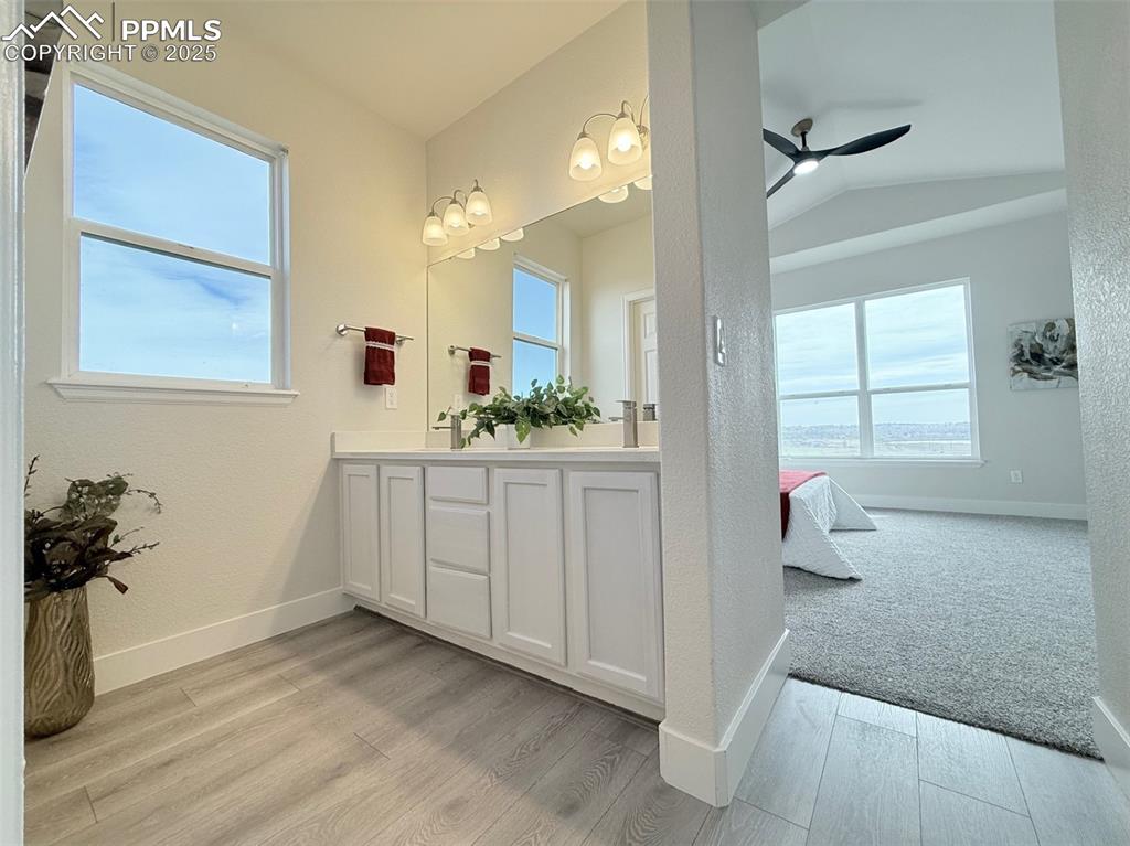 Image 26 of 49: Ensuite bathroom featuring double vanity, ceiling fan, light wood finished 