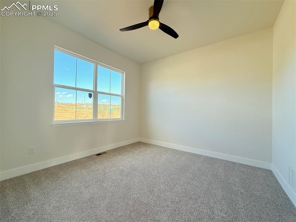 Image 27 of 49: Empty room with light colored carpet and ceiling fan