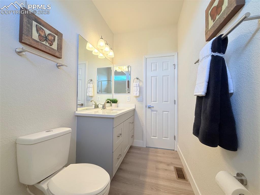 Image 30 of 49: Bathroom with vanity, light wood-type flooring, and a textured wall