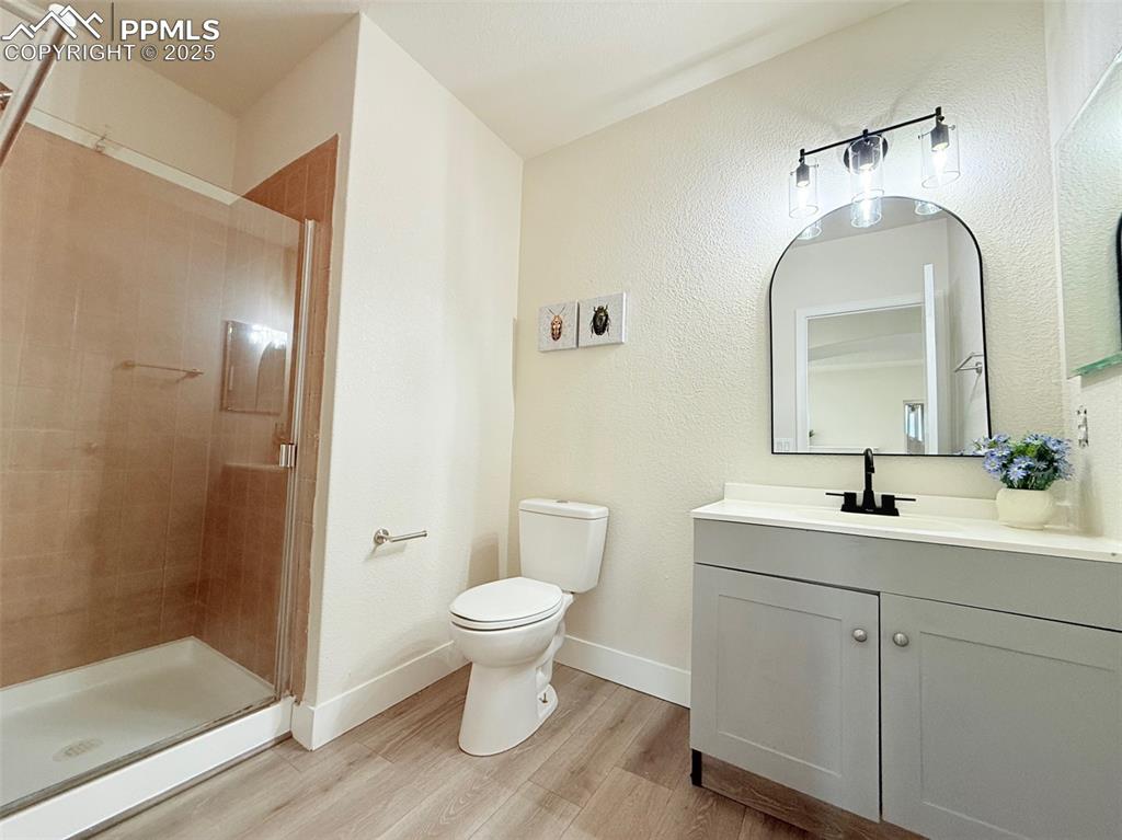 Image 36 of 49: Full bathroom featuring light wood-style floors, vanity, a stall shower, an