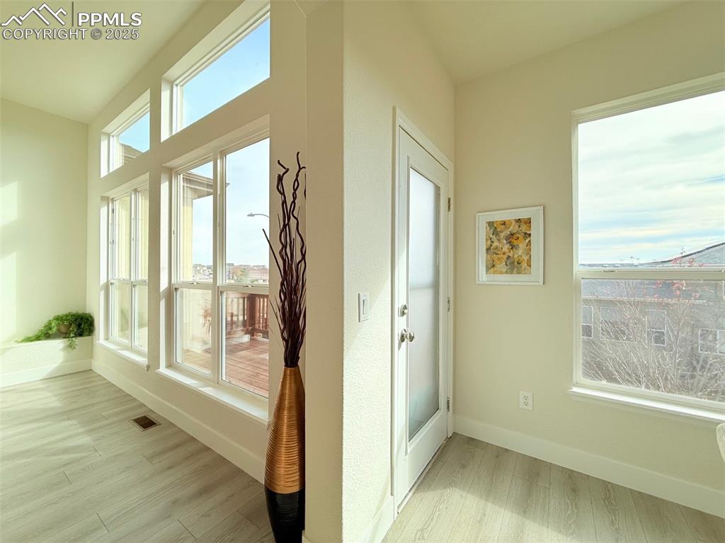 Image 38 of 49: Doorway featuring wood finished floors and baseboards