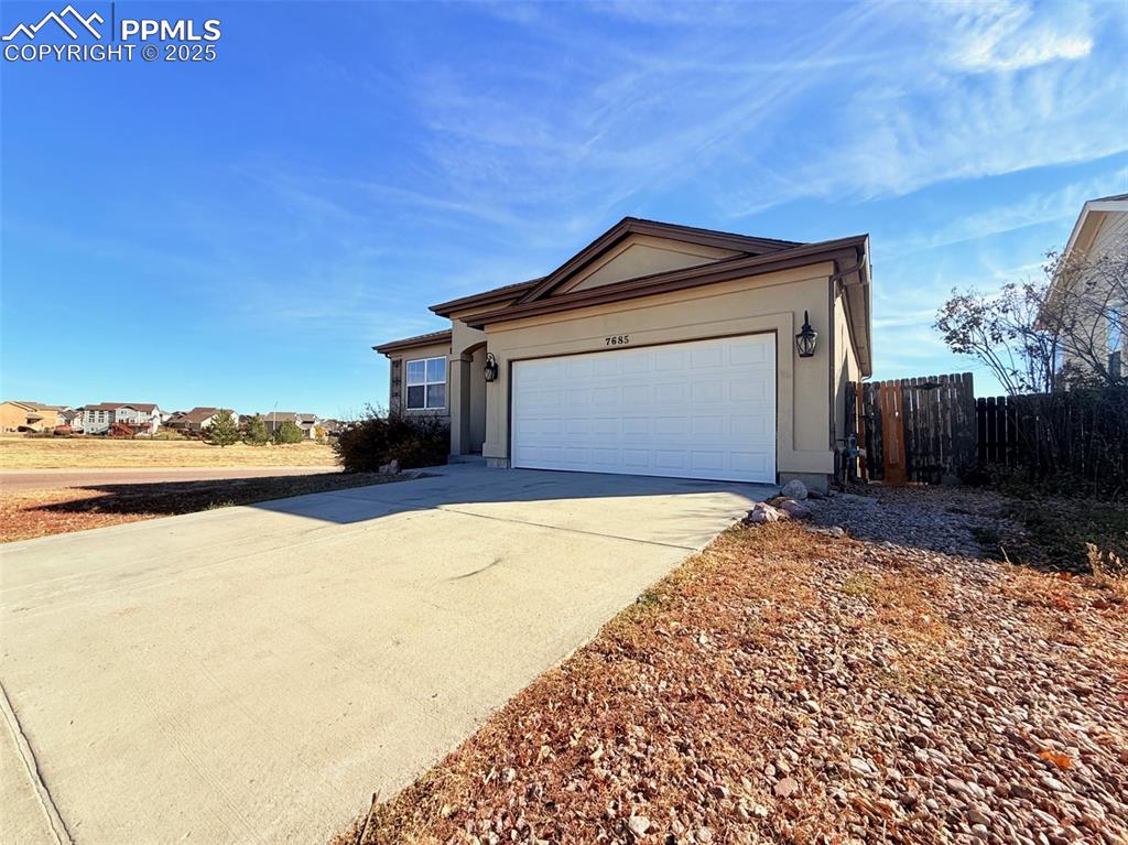Image 47 of 49: Ranch-style house featuring concrete driveway and a garage