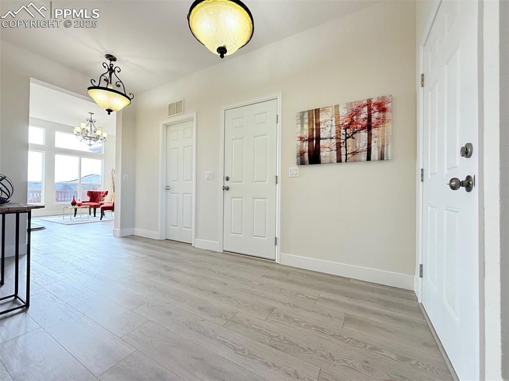 Image 5 of 49: Foyer entrance with light wood-type flooring and a chandelier