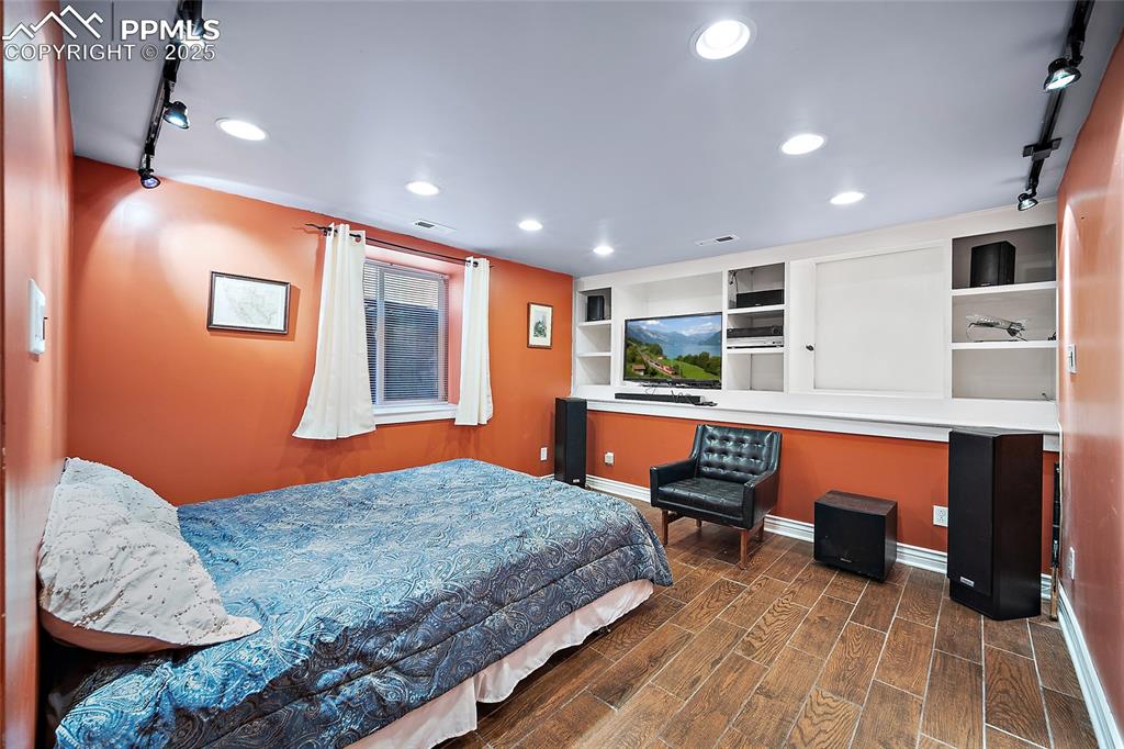 Image 31 of 39: Basement bedroom. wood grain tile flooring. 