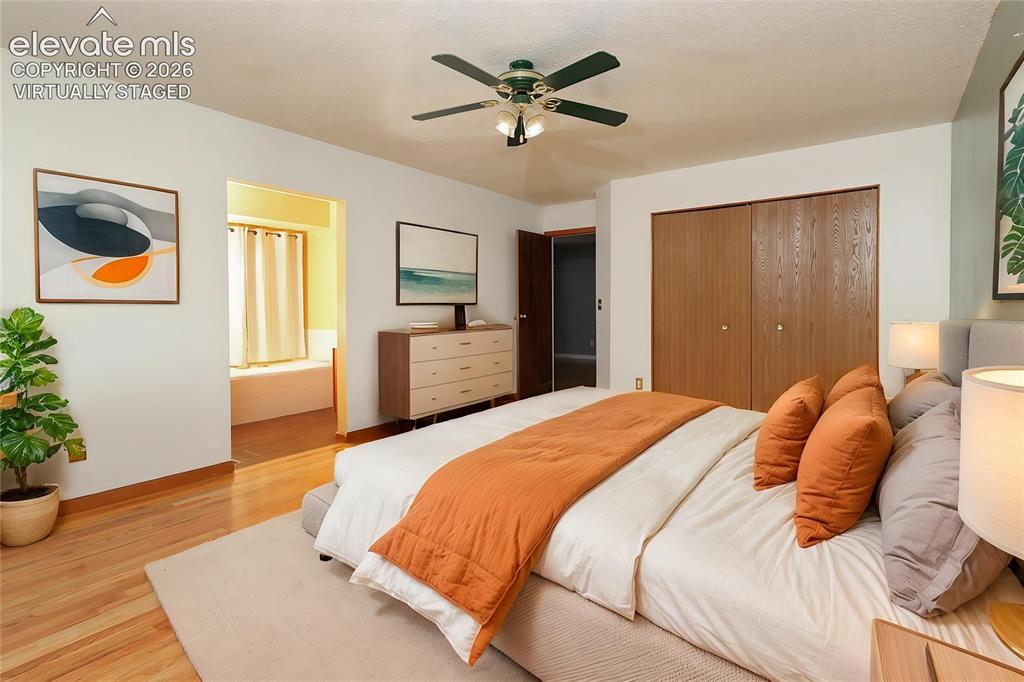 Image 11 of 32: Spacious bedroom featuring wood-finish flooring, a ceiling fan with integra