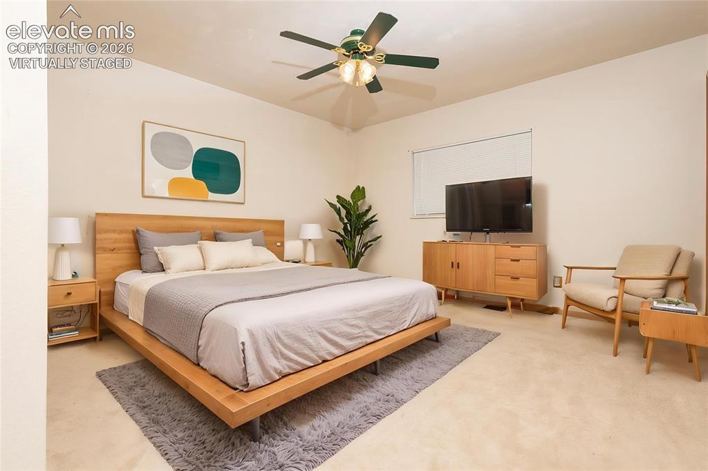 Image 16 of 32: Carpeted bedroom with a ceiling fan, light-toned walls, and a window featur
