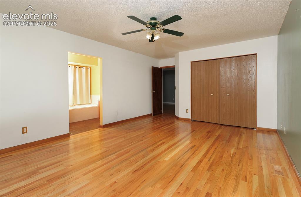 Image 27 of 32: Hardwood flooring throughout featuring bi-fold closet doors and a ceiling f